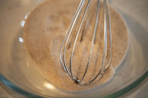 Cinnamon and sugar mixed with whisk in a bowl