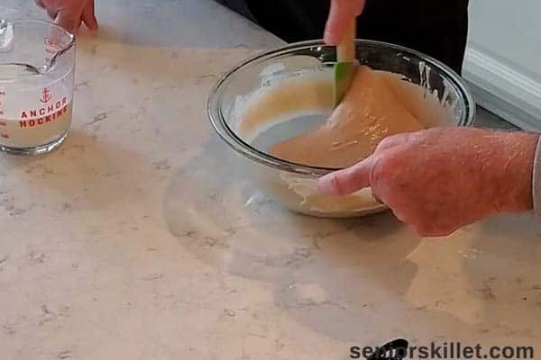 Mixing milk into cobbler batter