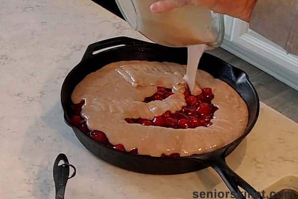 Pouring batter over cherries