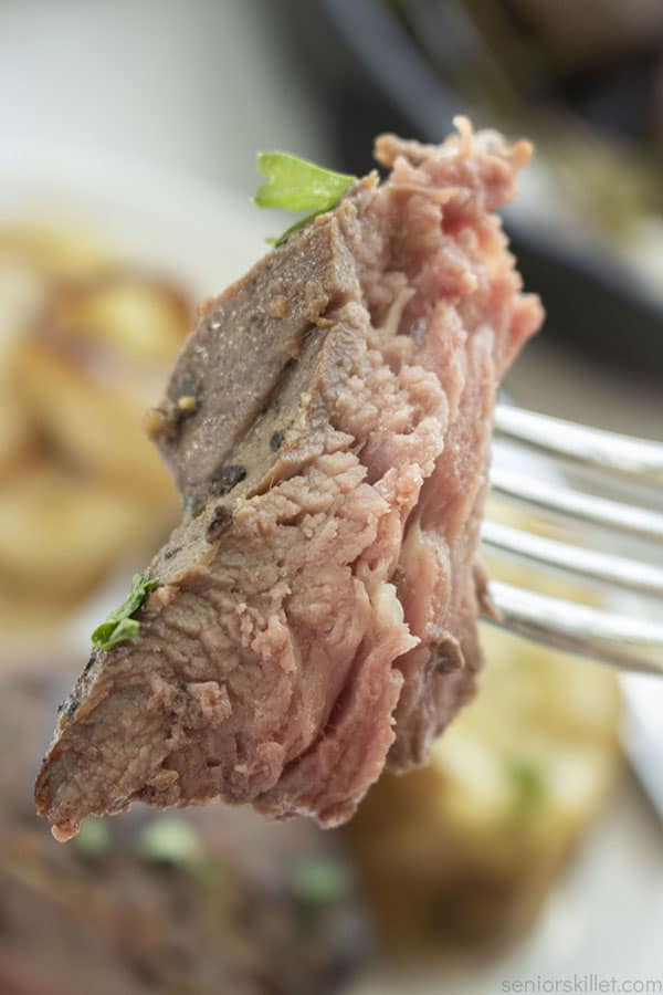 Closeup of cooked steak on a fork