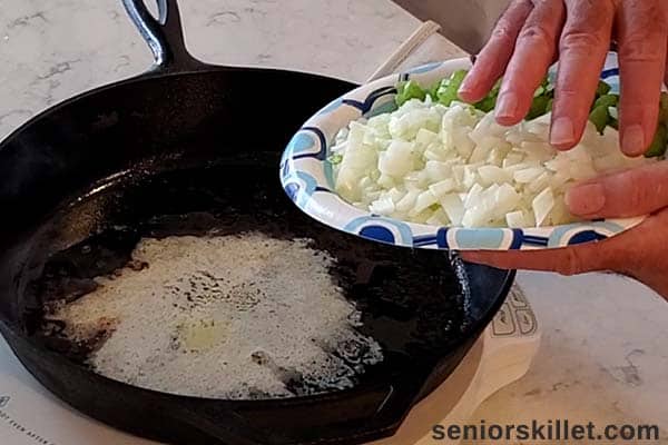 Adding vegetables to pan