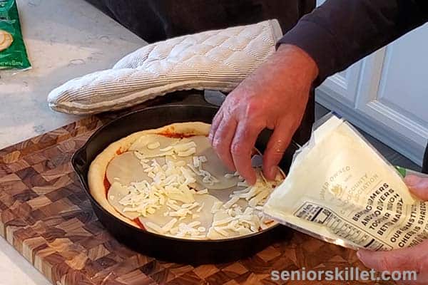 Adding mozzarella to pizza