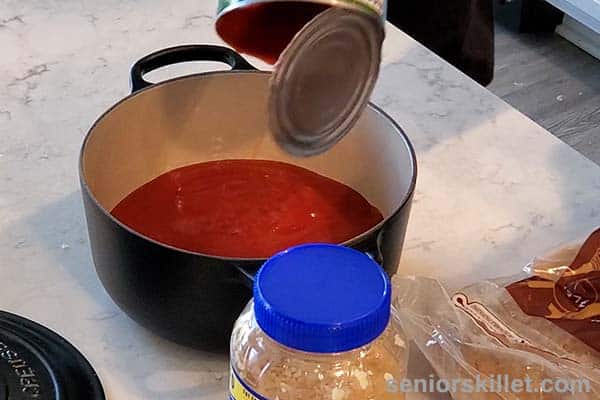 Adding tomato puree to pot