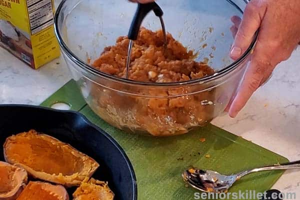 sweet potatoes being mashed in a bowl